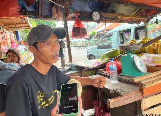 Angga, 45 tahun, pedagang buah sekaligus saksi kasus penjambretan ibu-ibu di depan Pasar Palmerah, Gelora, Tanah Abang, Jakarta Pusat, Sabtu, 23 Agustus 2025. (Sumber: Poskota/Pandi Ramedhan)