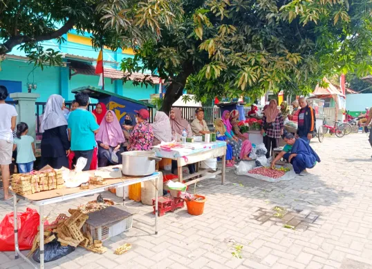 Pedagang Pasar Pejuang Pratama, Medan Satria, Kota Bekasi, terpaksa menggelar lapak darurat di depan kios mereka yang ludes dilalap api pada Sabtu, 23 Agustus 2025 malam. (Sumber: Poskota/Nurpini Aulia Rapika)