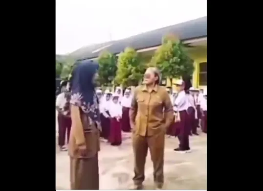 Viral video memperlihatkan guru perempuan berseragam ASN yang diduga melakukan intimidasi terhadap guru lain dan siswa saat upacara bendera di SDN 9 Kedondong, Kabupaten Pesawaran, Lampung. (Sumber: X/@B3doel___)