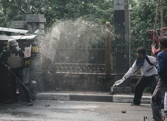 Sejumlah massa aksi berhadapan dengan aparat saat demo di belakang DPR dan Pejompongan, Jakarta, Senin, 25 Agustus 2025. (Sumber: Poskota/Bilal Nugraha Ginanjar)