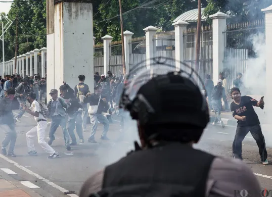 Aparat kepolisian menembakkan gas air mata di belakang DPR dan Pejompongan, Jakarta, Senin, 25 Agustus 2025. (Sumber: Poskota/Bilal Nugraha Ginanjar)