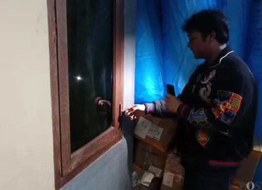 Pegawai toko online, Aldo, menunjukkan jendela yang dirusak maling untuk melancarkan malingnya, Senin 25 Agustus 2025. (Sumber: POSKOTA | Foto: Giffar Rivana)