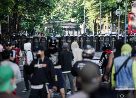Massa aksi menantang pihak kepolisian dalam demonstrasi di depan Mako Brimob Polda Metro Jaya, Kwitang, Jakarta Pusat, Jumat, 29. Agustus 2025. (Sumber: Poskota/Bilal Nugraha Ginanjar)