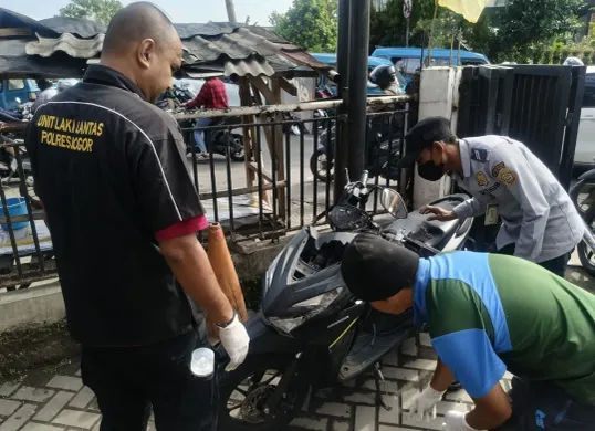 Petugas memeriksa motor korban yang tewas di Jalan Raya Dramaga, karena terlindas truk Pertamina, Jumat 29 Agustus 2026. (Sumber: Istimewa)