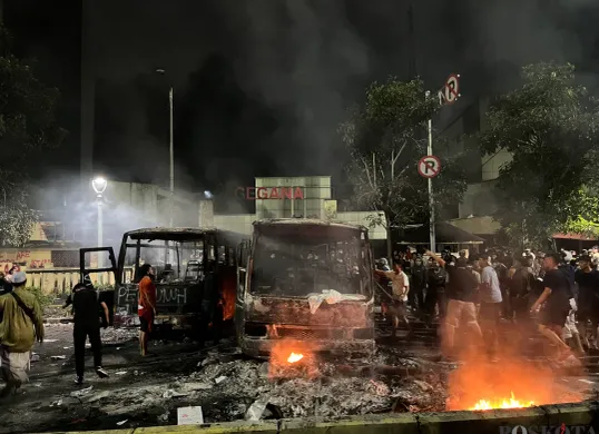 Warga berusaha memindahkan bus yang terbakar agar pemadam kebakaran bisa dapat akses di depan Gedung GEGANA, Jakarta Pusat, Sabtu, 30 Agustus 2025 dini hari. (Sumber: Poskota/Pandi Ramedhan)