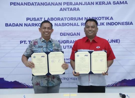 Kepala Pusat Laboratorium Narkotika BNN Supiyanto dan Kepala Cabang JNE Bogor Ade Kurniawan menunjukkan dokumen Perjanjian Kerja Sama yang baru ditandatangani di Bogor. (Sumber: Biro Humas dan Protokol BNN)