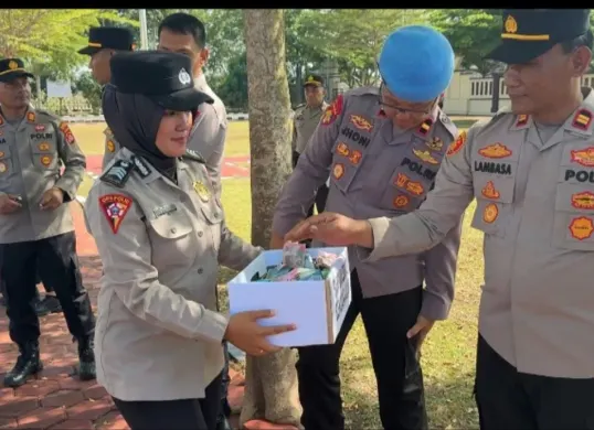 Satu petugas tengah mengumpulkan dana peduli bencana usai apel pagi di Mapolres Serang. (Sumber: Humas Polres Serang)