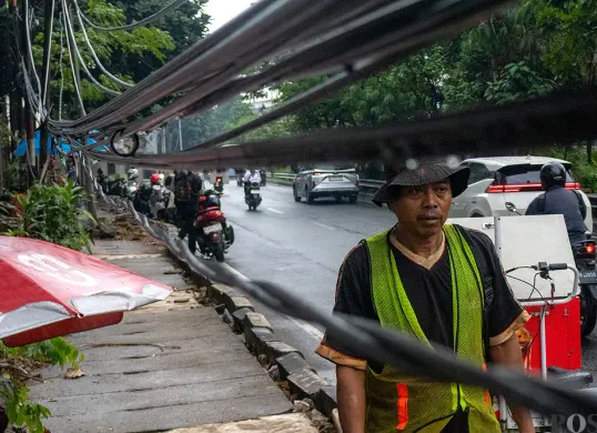 Kabel-kabel listrik menjuntai di sepanjang Jalan Tahi Bonar (TB) Simatupang arah Pasar Rebo, Jakarta Selatan pada Selasa, 2 Desember 2025. (Sumber: POSKOTA | Foto: Dhiya Ahmad Fauzan/M2)