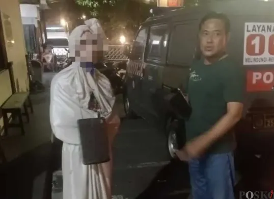 Polisi mengamankan remaja pengamen berkostum menyerupai pocong yang telah membuat resah masyarakat. (Sumber: Poskota/Angga Pahlevi)