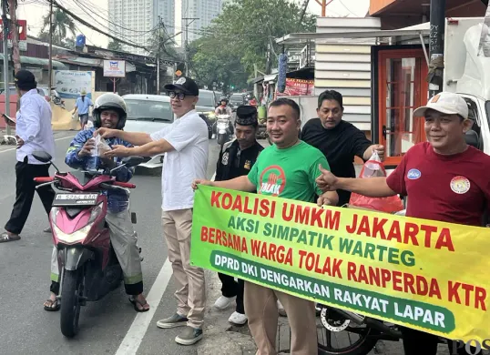 Komunitas pelaku usaha warteg dan UMKM membagikan nasi bungkus sebagai bentuk protes terhadap Raperda KTR di kawasan Kembangan, Jakarta Barat, Rabu, 3 Desember 2025. (Sumber: POSKOTA | Foto: Pandi Ramedhan)