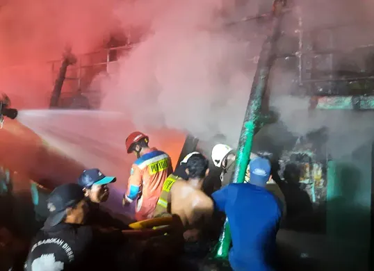 Petugas damkar melakukan pemadaman kapal nelayan yang terbakar di Dermaga Timur Pelabuhan Muara Baru, Penjaringan, pada Sabtu, 6 Desember 2025. (Sumber: Dok Damkar Jakut)