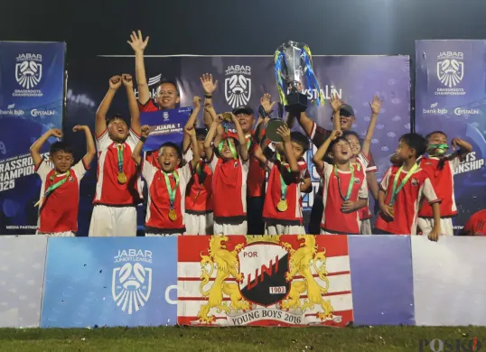Para pemain dan official SSB Por Uni 1903, mengangkat tropi Champions Series Jabar Junior League. (Sumber: Poskota/Gatot Poedji Utomo)