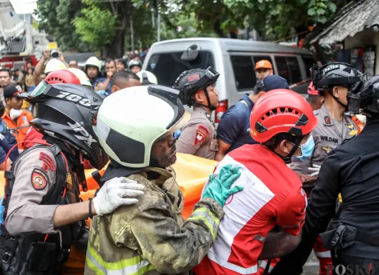 Petugas mengevakuasi jenazah korban kebakaran di perkantoran Terra Drone di Jalan Letjen Soeprapto, Cempaka Baru, Kemayoran, Jakarta Pusat, Selasa, 9 Desember 2025. (Sumber: POSKOTA | Foto: Bilal Nugraha Ginanjar)