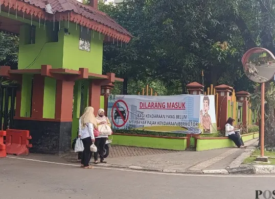 Pemkot Bekasi memasang spanduk sosialisasi larangan kendaraan belum bayar pajak masuk kantor. (Sumber: Poskota/Nurpini Aulia Rapika)