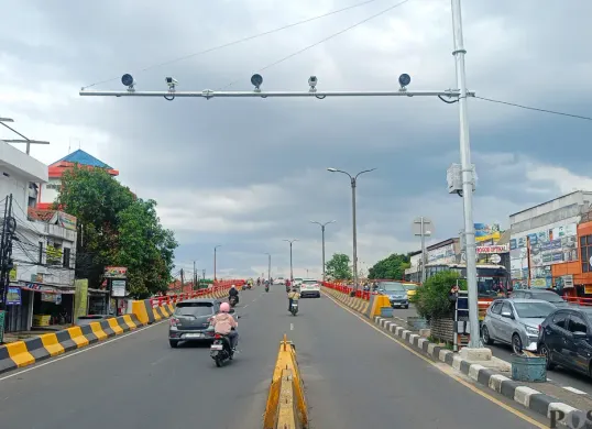 Pengendara melintas di bawah Kamera ETLE di Flyover Cibinong, Minggu 14 Desember 2025. (Sumber: Poskota/Giffar Rivana)