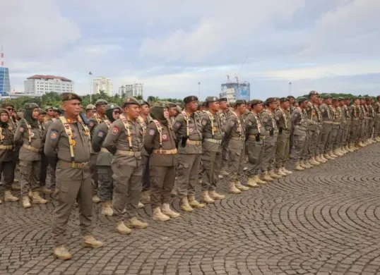 Ribuan personel Satpol PP DKI Jakarta saat menggelar apel gelar pasukan kesiapan pengamanan menjelang Hari Raya Natal 2025 dan Tahun Baru 2026 di Monas Sisi Selatan, Jakarta Pusat, pada Kamis, 18 Desember 2025. (Sumber: Kominfotik Satpol PP Jakarta)