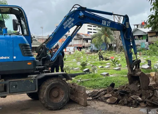 Salah satu ekskavator saat membersihkan lapak di TPU Kober Rawa Bunga, Jakarta Timur, Kamis, 18 Desember 2025. (Sumber: Poskota/M. Tegar Jihad)