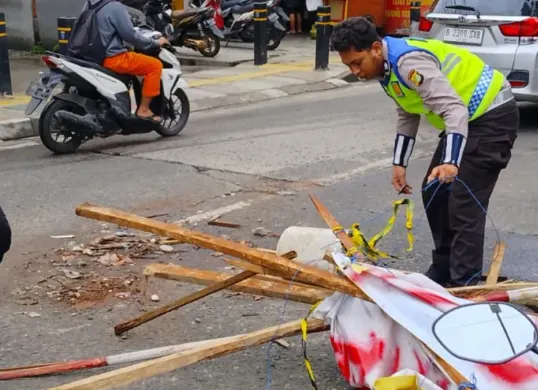 Anggota Kanit Lantas Polsek Cinere membersihkan sisa-siang puing pengerjaan proyek Jalan Cinere. (Sumber: Lantas Polsek Cinere)
