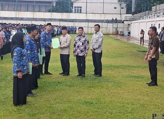 Wali Kota Depok, Supian Suri didampingi anggota DPRD Propinsi DPRD Provinsi Jawa Barat Pradi Supriatna melantik 7.036 Pegawai PPPK Paruh Waktu di tengah Guyuran Hujan. (Sumber: Poskota/Angga Pahlevi)