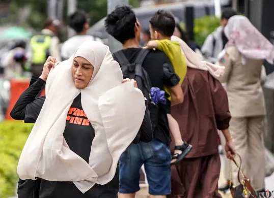 Ilustrasi, warga berjalan di tengah angin kencang di kawasan bundaran HI, Jakarta, Selasa, 16 Desember 2025. (Sumber: POSKOTA | Foto: Bilal Nugraha Ginanjar)