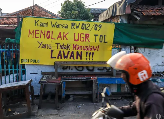 Spanduk penolakan uang ganti rugi proyek Tol Semanan-Sunter terpasang di permukiman RW 09 dan RW 12 Duri Pulo, Jakarta Pusat. (Sumber: POSKOTA | Foto: Dhiya Ahmad Fauzan/M2)