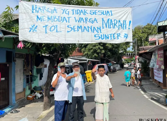 Ketua RW 09 Duri Pulo, Azhari Mukhlis (kiri) bersama warga foto dibawah spanduk bertuliskan protes penggusuran, Selasa, 23 Desember 2025. (Sumber: Poskota/M. Tegar Jihad)