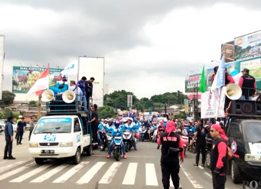 Ribuan massa aksi buruh melakukan pemblokiran akses Tol Balaraja Timur saat mengawal rekomendasi kenaikan UMK Tangerang 2026. (Sumber: Poskota/Veronica)