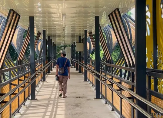 Seorang warga sedang menyebrang di JPO Kyai Tapa yang berada di kawasan Grogol Petamburan, Jakarta Barat pada Jumat, 26 Desember 2025. (Sumber: Poskota/Pandi Ramedhan)