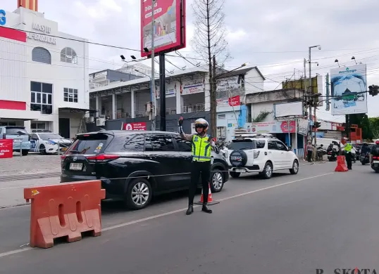 Anggota Satlantas Polres Cimahi melakukan pengamanan arus lalu lintas di kawasan Lembang, Kabupaten Bandung Barat, Sabtu 27 Desember 2025. (Sumber: Poskota | Foto: Gatot Poedji Utomo)