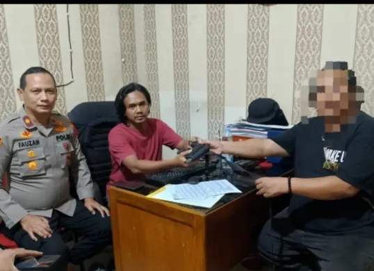 Petugas Polsek Bojongsari mengamankan pria berinisial ABK yang sempat viral karena memperlihatkan pistol mainan kepada petugas keamanan di Perumahan Exotica Hive, Sawangan, Depok. (Sumber: Istimewa)