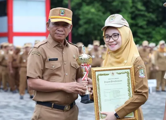 Sekretaris Daerah (Sekda) Kota Bekasi memberikan penghargaan terhadap ASN yang meraih prestasi di tahun 2025. (Sumber: Dok. Humas Pemkot Bekasi)