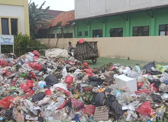 Tumpukan sampah rumah tangga menggunung di halaman Kantor Kelurahan Kebalen, Kecamatan Babelan, Kabupaten Bekasi, Senin 29 Desember 2025. (Sumber: Poskota/Nurpini Aulia Rapika.)