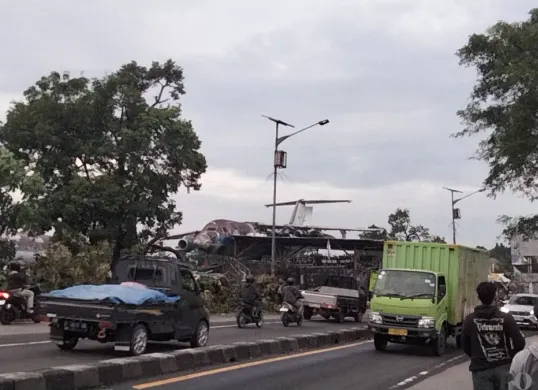 Bangkai pesawat di Jalan Raya Parung, Kabupaten Bogor, Jawa Barat. (Sumber: Poskota/Giffar Rivana)