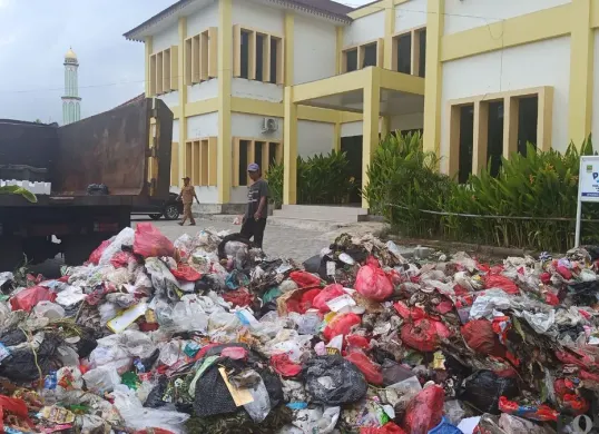 Tumpukan sampah rumah tangga menggunung di halaman Kantor Kelurahan Kebalen, Kecamatan Babelan, Kabupaten Bekasi, Senin, 29 Desember 2025. (Sumber: Poskota/Nurpini Aulia Rapika)