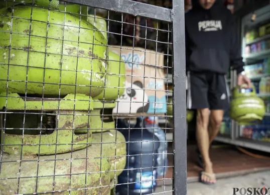 Warga membawa dua tabung gas elpiji 3 Kg yang dibelinya dari warung kelontong di kawasan Palmerah, Jakarta Barat. (Sumber: Poskota/Bilal Nugraha Ginanjar)