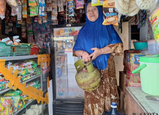 Leni, 58 tahun, pemilik toko kelontongan di Babelan, Kabupaten Bekasi memperlihatkan gas tabung 3 kilogram yang dijual eceran, Sabtu, 1 Februari 2025. (Sumber: Poskota/Ihsan Fahmi)