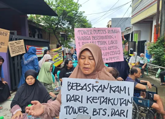 Warga Perumahan Telaga Mas, Bekasi Utara, Kota Bekasi memperlihatkan poster protes mereka saat dijumpai di lokasi, Minggu, 2 Februari 2025. (Sumber: Poskota/Ihsan Fahmi)