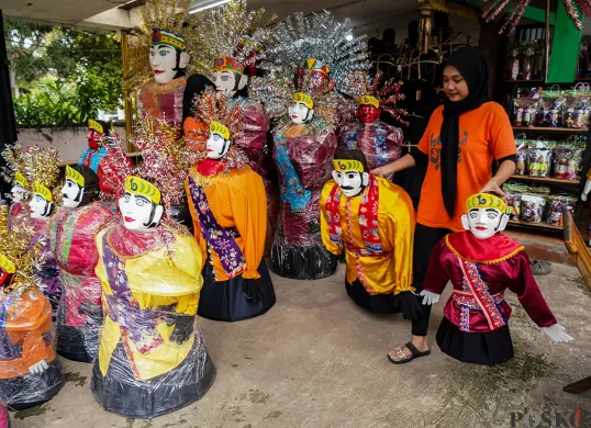 Pengrajin memotong kayu rangka boneka khas betawi 'Ondel-ondel' sekaligus memasarkannya melalui galeri Betawi Online Gallery di Setu Babakan, Jakarta Selatan, Senin, 10 Februari 2025. (Sumber: Poskoata/ Bilal Nugraha Ginanjar)