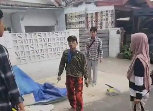 Tangkapan layar video viral bang jago berseragam ormas mengamuk dan todongkan senjata tajam ke guru TK. (Sumber: Poskota/Veronica Prasetio)