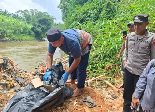 Petugas mengevakuasi jasad bayi laki-laki tersangkut bambu di Kali Ciliwung, Bojonggede, Kabupaten Bogor, Rabu, 19 Februari 2025. (Sumber: Poskota/Angga Pahlevi)