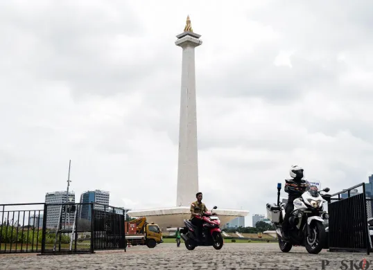 Pengendara melintasi jalan di depan Monas, Jakarta Pusat, Rabu, 19 Februari 2025. (Sumber: Poskota/Bilal Nugraha Ginanjar)