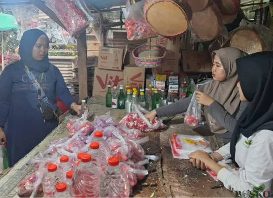 Mila (jilbab cokelat) bersama sepupunya sedang melayani pelanggan yang membeli bunga makam di lapaknya di TPU Perwira, Bekasi Utara, Kota Bekasi, Minggu, 23 Februari 2025. (Sumber: Poskota/Ihsan Fahmi)