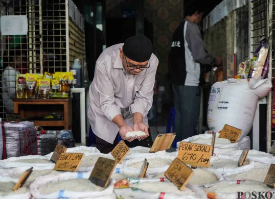 Pembeli mengecek beras yang dijual di Pasar Induk Beras Cipinang, Jakarta Timur, Sabtu, 22 Februari 2025. Menurut data Dinas KPKP DKI Jakarta, stok beras masuk dalam kategori aman. (Sumber: Poskota/Bilal Nugraha Ginanjar)