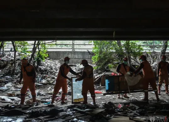 Petugas Suku Dinas Jakarta Barat, membersihkan sisa reruntuhan pemukiman di bawah Kolong Tol Angke, Grogol Petamburan, Jakarta Barat, Selasa, 7 Januari 2025. (Sumber: Poskota/Bilal Nugraha Ginanjar)