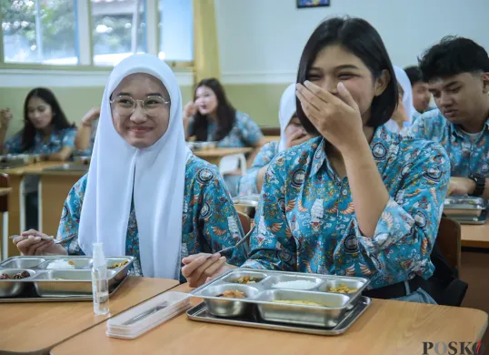 Ilustrasi - Dua orang siswi di salah satu sekolah Jakarta tersenyum sesaat sebelum menyantap Makan Bergizi Gratis yang diberikan. (Sumber: Poskota/ Bilal Nugraha Ginanjar)