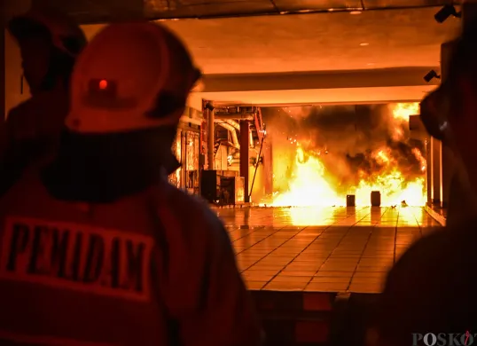 Sejumlah petugas pemadam kebakaran berupaya memadamkan kobaran api sambil mengevakuasi warga yang terjebak dari musibah kebakaran di Glodok Plaza, Tamansari, Jakarta Barat, Rabu 15 Januari 2025. (Sumber: Poskota/Bilal Nugraha Ginanjar)