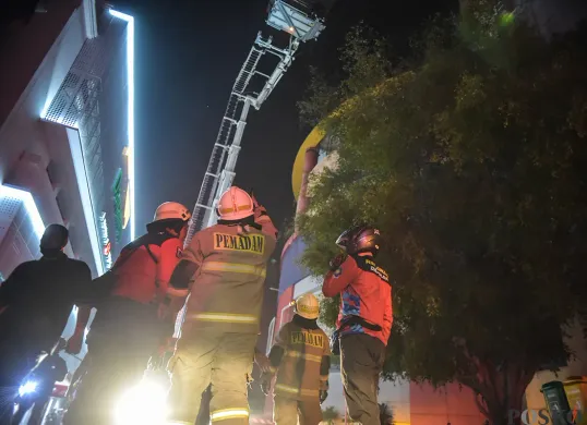 Sejumlah petugas pemadam kebakaran berupaya memadamkan kobaran api sambil mengevakuasi warga yang terjebak dari musibah kebakaran di Glodok Plaza, Tamansari, Jakarta Barat, Rabu 15 Januari 2025. (Sumber: Poskota/Bilal Nugraha Ginanjar)