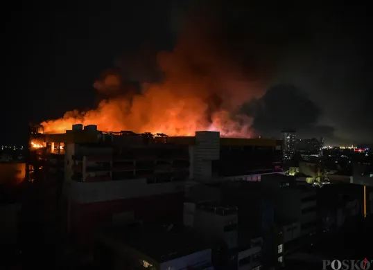 Sejumlah petugas pemadam kebakaran berupaya memadamkan kobaran api sambil mengevakuasi warga yang terjebak dari musibah kebakaran di Glodok Plaza, Tamansari, Jakarta Barat, Rabu 15 Januari 2025. (Poskota/Bilal Nugraha Ginanjar)