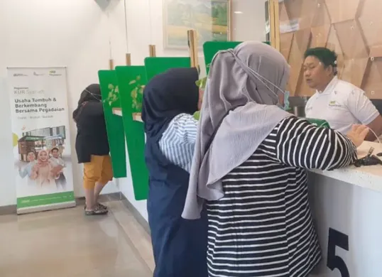 Pelaku UMKM tengah mengajukan KUR Syariah di kantor Pegadaian terdekat. Program ini membantu pengembangan usaha dengan bunga rendah dan syarat fleksibel. (Sumber: Pinterest)