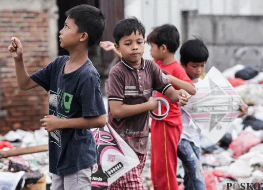 Anak-anak bermain layang-layang di lahan kosong, Kampung Boncos, Jakarta, 3 Juli 2025. (Sumber: Poskota/Bilal Nugraha Ginanjar)